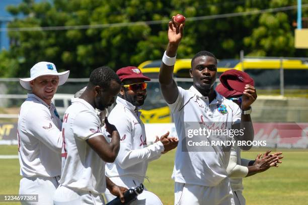 Jayden Seales of West Indies waves the ball and cap celebrating his five wicket haul during day 4 of the 1st Test between West Indies and Pakistan at...