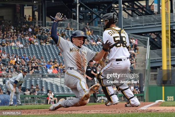 Willy Adames of the Milwaukee Brewers slides in safely to score a run on a RBI double by Christian Yelich in the third inning during the game against...