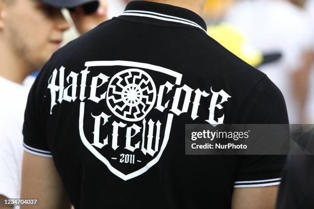 Man with a shirt with a black sun Nazi symbol is seen ahead of a nationalist march on 15 August, 2021 in Warsaw, Poland. A march organized by the...