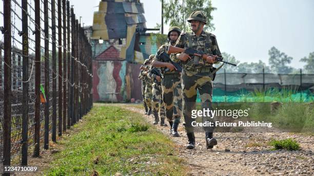 Border Security Force personnel patrolling along the barbed wire fence at India-Pakistan border during Independence Day celebrations at RS Pura...