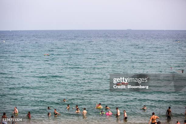 Beachgoers cool in the sea at Barceloneta beach in Barcelona, Spain, on Sunday, Aug. 15, 2021. A dangerous heatwave is sweeping across the...