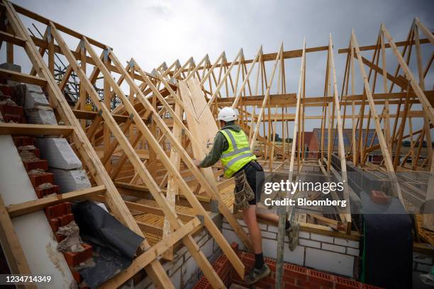 Worker secures wood roofing trusses on a Persimmon Plc residential property construction site in Chelmsford, U.K., on Monday, Aug. 16, 2021....