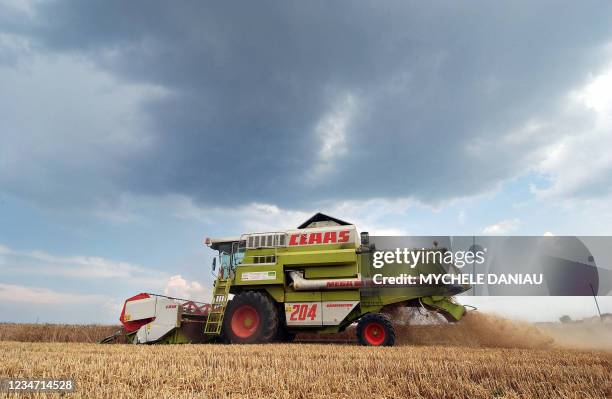 Un agriculteur moissonne un champs de blé, le 19 juillet 2006 à Giberville. Le prix du blé, dopé par la "canicule", continue à grimper, dans un...