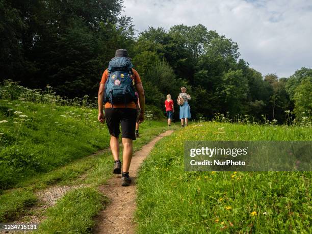 Man is walking around a mountain slope, during the new route, The Dutch Mountain Trail around the South of Limburg, in The Netherlands, on August...