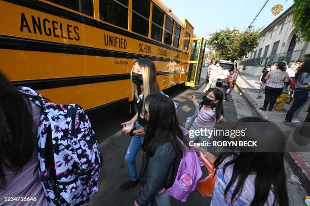 Students and parents arrive masked for the first day of the school year at Grant Elementary School in Los Angeles, California, August 16, 2021. - To...