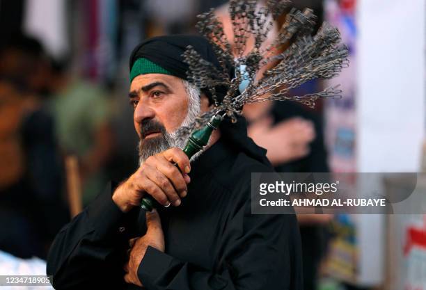 An Iraqi Shiite Muslim man beats himself with chains during a mourning procession during the month of Muharram leading up to the day of Ashura, in...