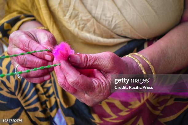 Woman making a sacred thread 'Rakhi' ahead of the Raksha Bandhan festival in Kolkata.