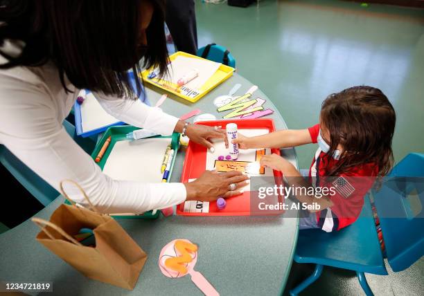 Normont Early Education Center teacher Vernida Watson helps student Lazarus Alvarado as School on the first day of in class instruction on August 16,...