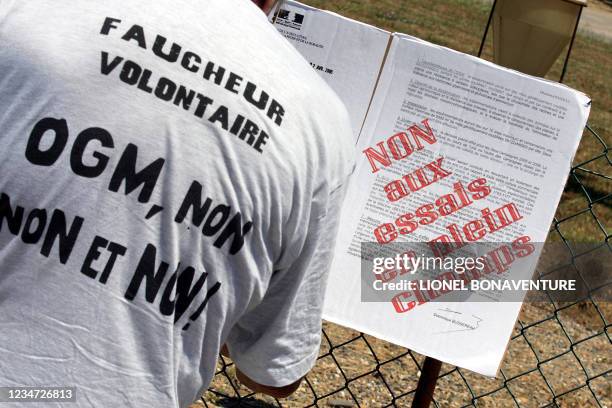 Un manifestant du collectif "Faucheurs Volontaires de Midi-Pyrénées" accroche, le 18 juin 2005 à Mondonville, un texte pour protester contre les...