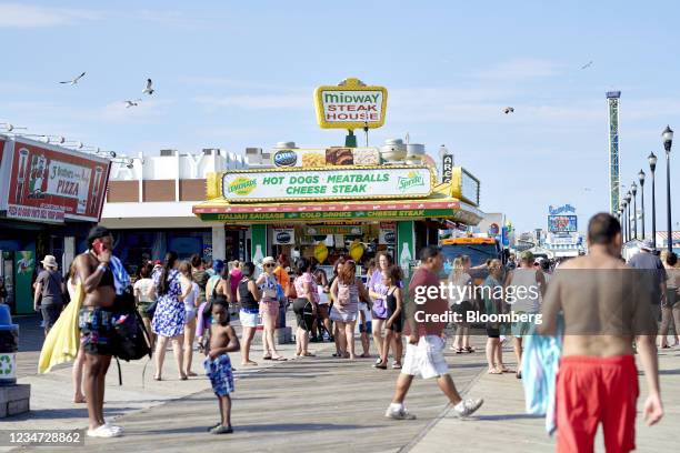 Pedestrians walk along the boardwalk in Seaside Heights, New Jersey, U.S., on Sunday, Aug. 15, 2021. On Monday, New Jersey reported another 1,145...
