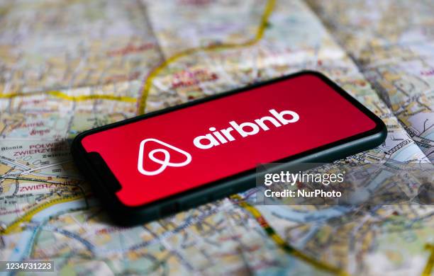 Airbnb logo displayed on a phone screen and a map of Krakow are seen in this illustration photo taken in Krakow, Poland on August 17, 2021.