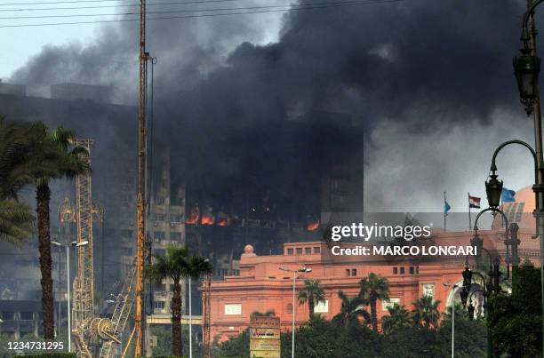 Smoke billows from a building adjacent to the Egyptian museum in the central Tahrir square in Cairo on January 29, 2011 as thousands of anti-regime...