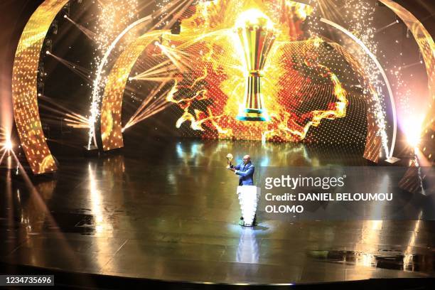 Roger Milla, former Cameroonian footballer, carrying the African Cup of Nations trophy during the draw ceremony for the 2022 African Cup of Nations...