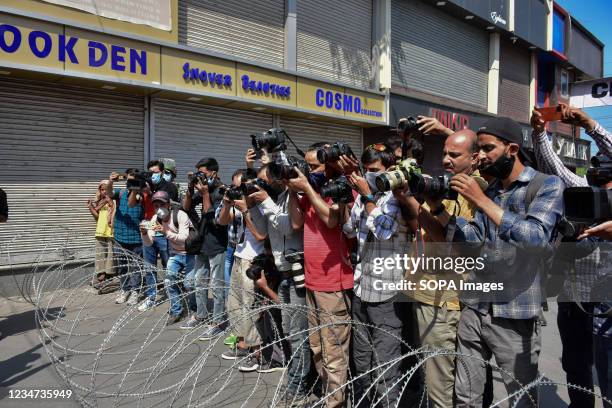 Kashmiri journalists take pictures of Shiite mourners during a Muharram procession in Srinagar. Authorities imposed restrictions in parts of Srinagar...