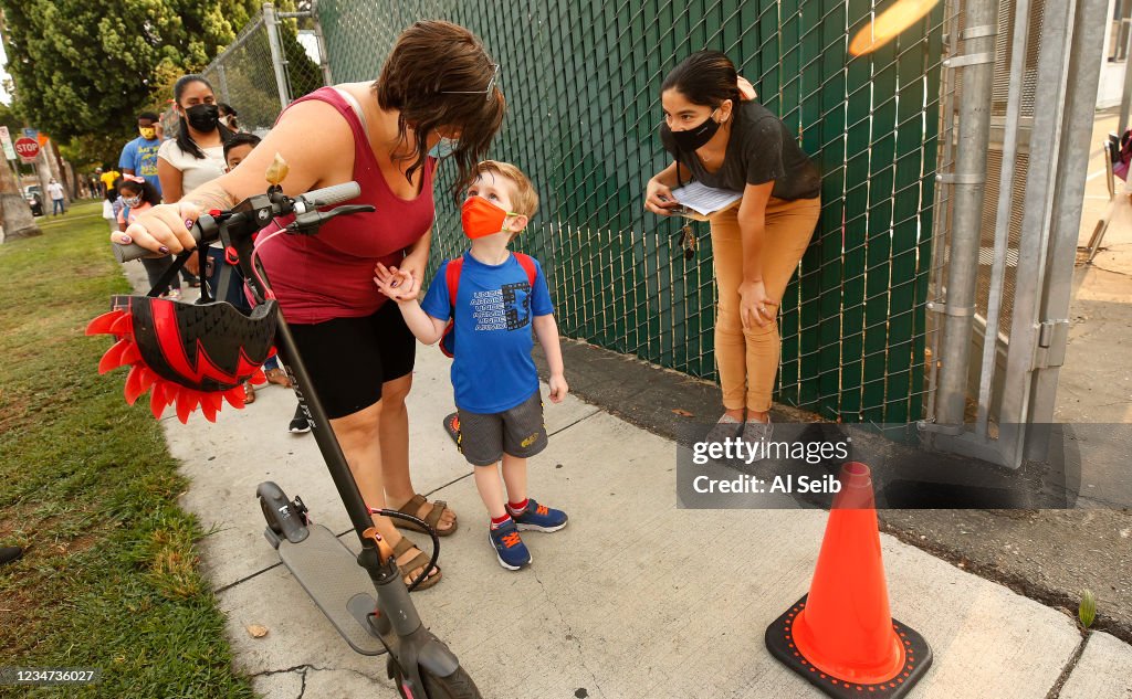 Parents and students wait in line to check for the student name on a list or present their QR code for entrance to the campus at Lankershim Elementary School in North Hollywood on Tuesday for the second day of in-class learning for LAUSD schools.