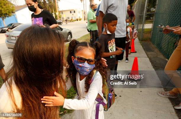 Kindergartner Rylee Doan gets in a last hug with her mother Tiffany Doan-Evans at Lankershim Elementary School in North Hollywood as parents and...