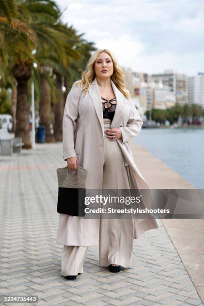 In this image released on August 17, US actress and plus size model Hayley Amber Hasselhoff wearing a long beige coat by Marina Rinaldi, beige high...