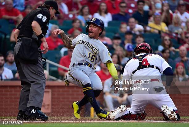 Kolten Wong of the Milwaukee Brewers reacts after being tagged out at the plate by Yadier Molina of the St. Louis Cardinals in the first inning at...
