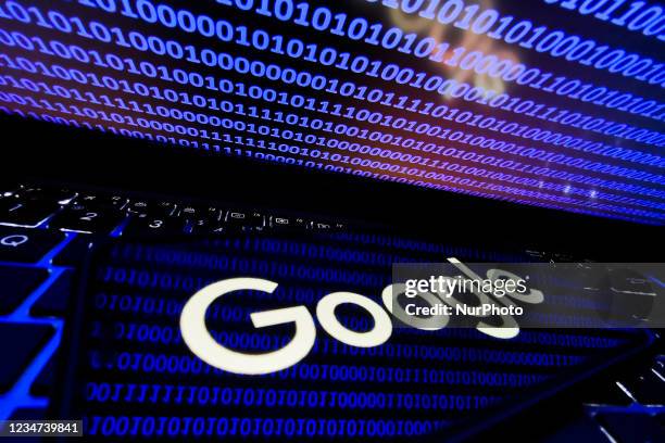 Google logo displayed on a phone screen is seen with binary code displayed on a laptop screen in this illustration photo taken in Krakow, Poland on...