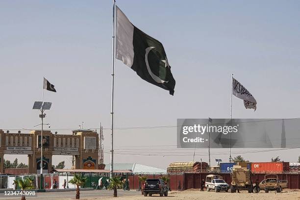 Pakistani flags and Taliban flag flutter on their respective border sides as seen from the Pakistan-Afghanistan border crossing point in Chaman on...