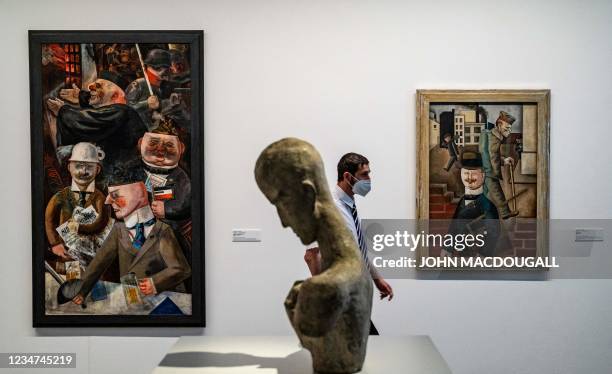Man passes by German artist George Grosz's "Grey Day" , "Pillars of Society" and German sulptor Wilhelm Lehmbruck's (Head of a Thinker " on display...