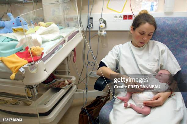 Une personne câline son bébé prématuré, le 01 octobre 2004 au CHU de Brest. Associer les parents aux soins des prématurés, en faire de véritables...