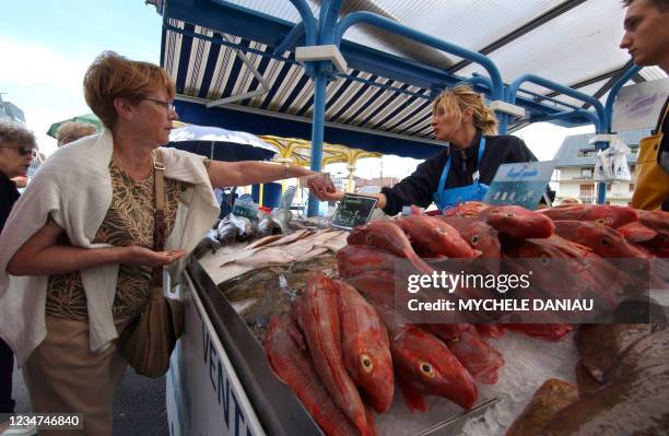 Photo prise le 12 août 2004 sur le petit marché du port de Courseulles-sur-Mer qui attire de nombreux vacanciers venus acheter du poisson fraîchement...