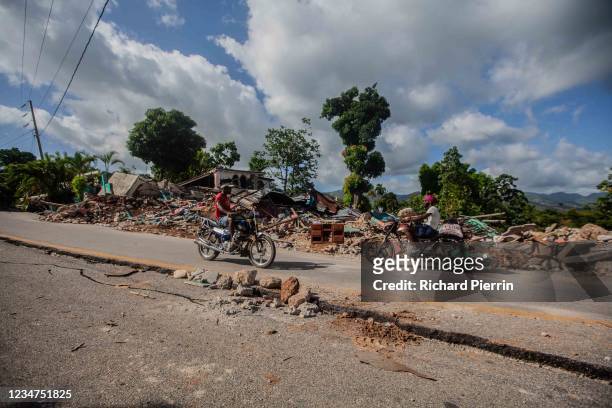 People drive by the damage after a 7.2-magnitude earthquake struck Haiti on August 18, 2021 in Marceline, Camp-Perrin, Haiti. Rescue efforts continue...