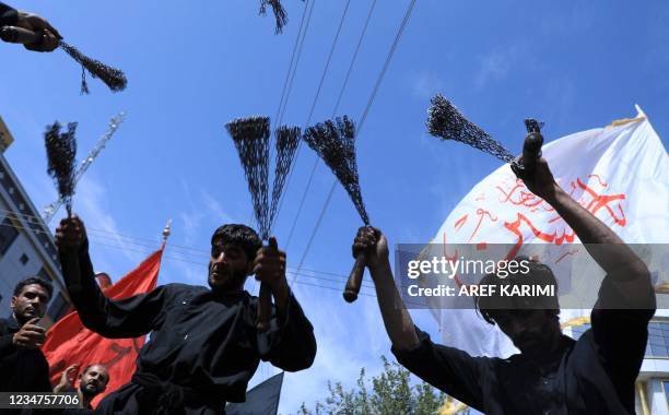 Shiite Muslims self-flagellate themselves during an Ashura procession held to mark the death of Imam Hussein, the grandson of Prophet Mohammad, along...