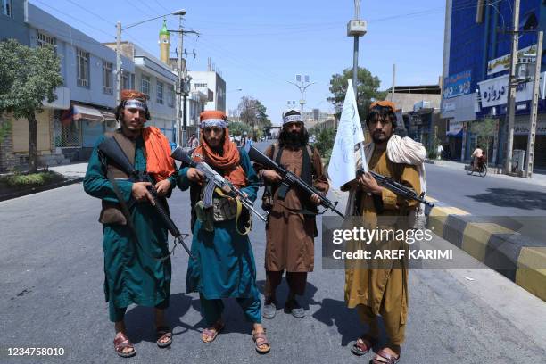 Taliban fighters stand guard along a road near the site of an Ashura procession which is held to mark the death of Imam Hussein, the grandson of...