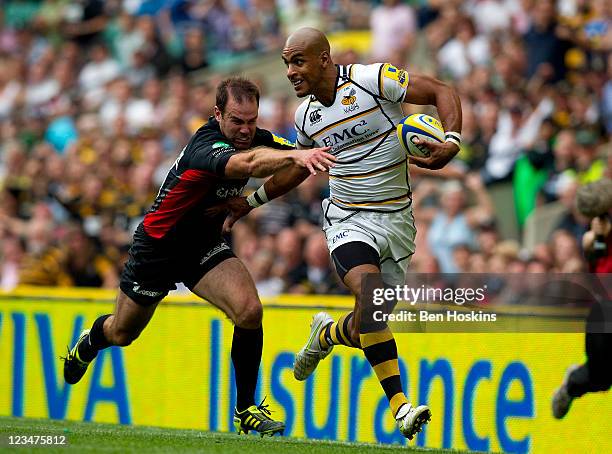 Tom Varndell of Wasps breaks away from the tackle of Charlie Hodgson of Saracens to score the winning try during the AVIVA Premiership match between...