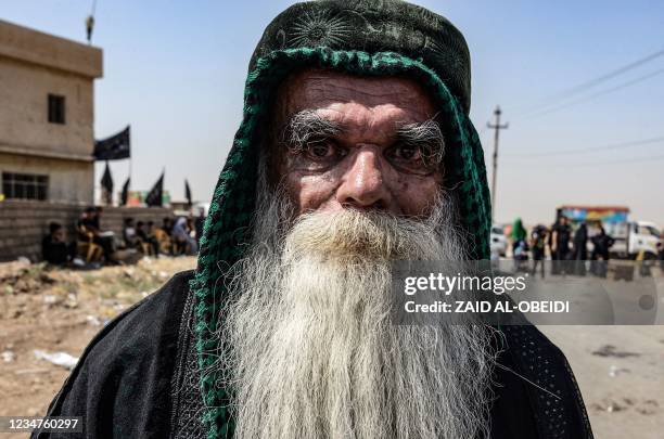 An elderly Iraqi man joins pilgrims as they walk toward the shrine of Imam Zayn al-Abidin, the fourth Imam of Shiite Muslims and great grandson of...