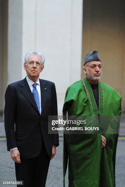 Italian Prime Minister Mario Monti and Afghanistan's President Hamid Karzai review an honour guard prior their meeting on January 26, 2012 at Palazzo...