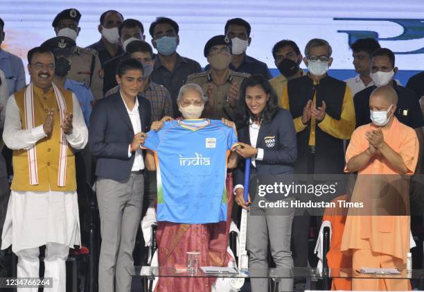 Indian women's hockey team present their jersey to Governor Anandi Ben Patel and Uttar Pradesh Chief Minister Yogi Adityanath at a felicitation...