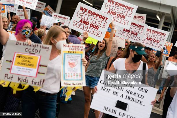 Pro- and anti-mask demonstrators hold signs and chant during a rally over Cobb School District's optional mask policy in Marietta, Georgia, U.S., on...