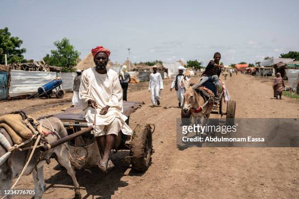 An Eritrean man sits on his donkey drawn cart through the market of Shagarab refugee camp on August 15 in Shagarab, Sudan. Situated about 70 km west...