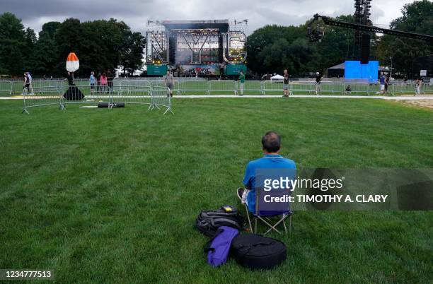 Man sits at Central Park's Great Lawn in New York on August 20 a day before the "We Love NYC: The Homecoming Concert" a the culmination of NYC...