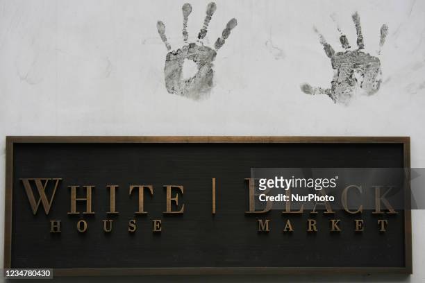 Handprints over a sign that says 'White House Black Market' in New York City, USA.