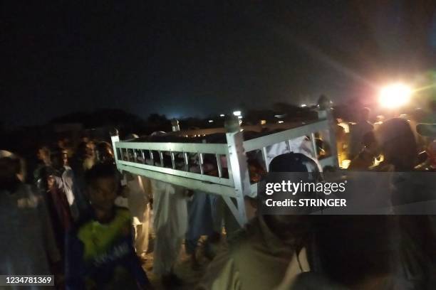 Residents carry the coffin of a suicide attack victim in the port city of Gwadar on August 20, 2021. - At least two children were killed and a...