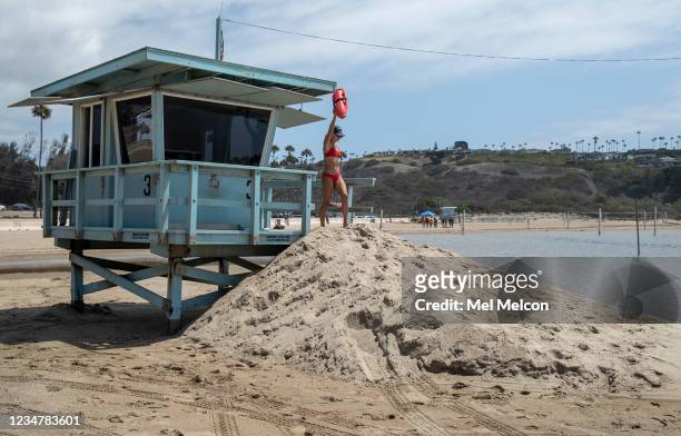 Ocean lifeguard Tiana Pugliese makes her way down from a lifeguard tower at Zuma Beach that was relocated further back from the ocean as a result of...