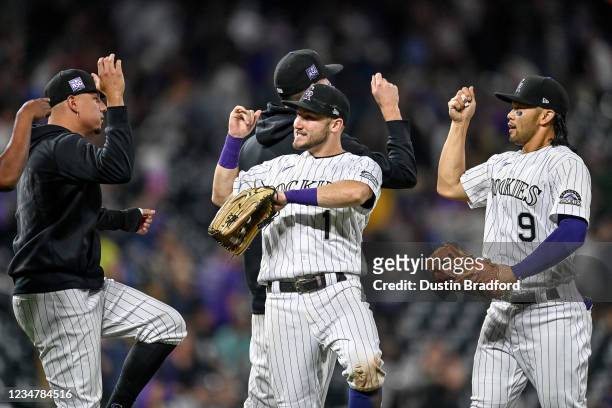 Connor Joe and Garrett Hampson of the Colorado Rockies celebrate with Yonathan Daza as they walk off the field after a 9-4 win over the Arizona...