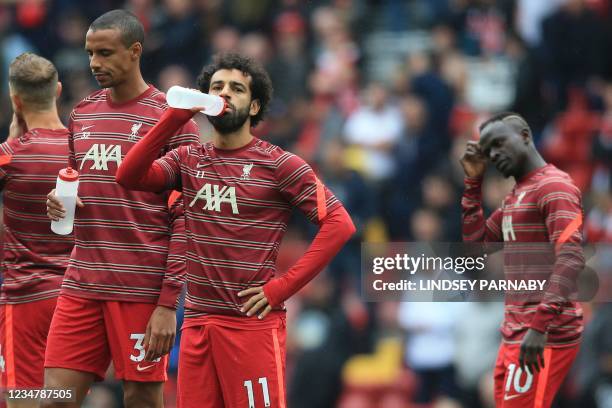 Liverpool's Egyptian midfielder Mohamed Salah sips water as he warms up with teammates ahead of the English Premier League football match between...