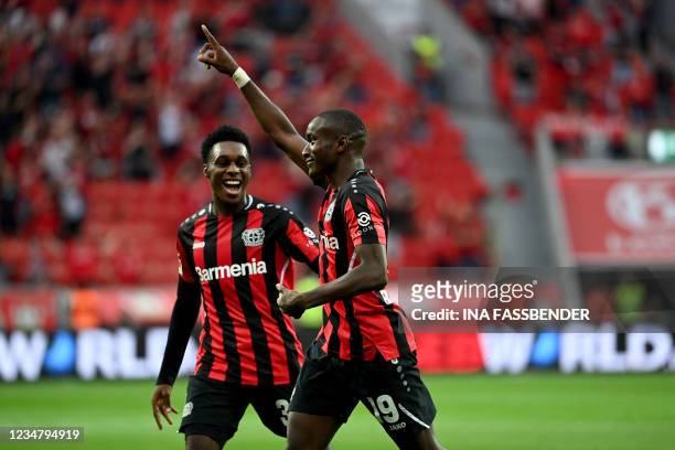 Leverkusen's French forward Moussa Diaby celebrates with Leverkusen's Dutch defender Jeremie Frimpong after scoring the 3-0 during the German first...