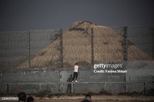 Palestinian protesters take part in a demonstration at the border fence with Israel, denouncing the Israeli siege of the Palestinian strip, during a...