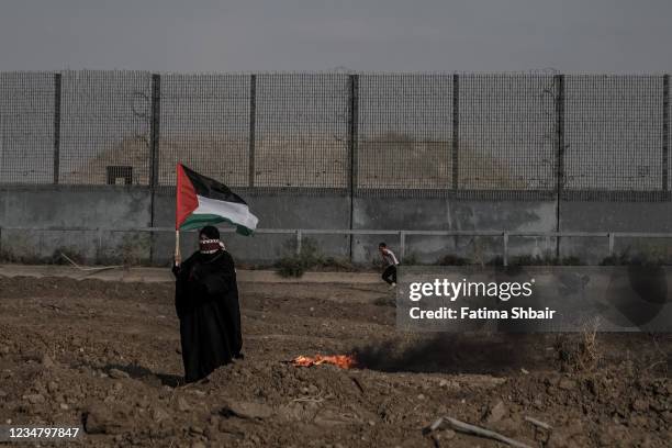 Palestinian protesters take part in a demonstration at the border fence with Israel, denouncing the Israeli siege of the Palestinian strip, during a...