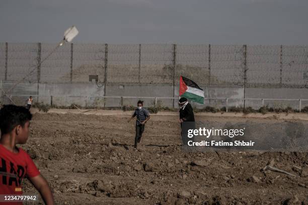 Palestinian protesters take part in a demonstration at the border fence with Israel, denouncing the Israeli siege of the Palestinian strip, during a...