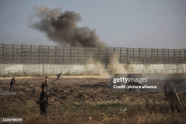 August 2021, Palestinian Territories, Gaza: Palestinian protesters clash with Israeli security forces following a demonstration at the border fence...