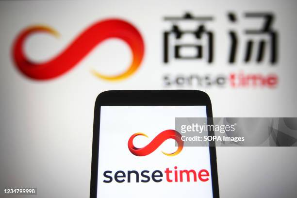 In this photo illustration, SenseTime logo is seen displayed on a smartphone and a pc screen.