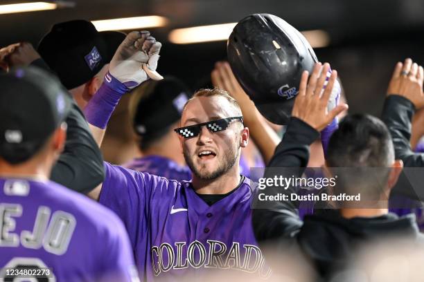 Garrett Hampson of the Colorado Rockies celebrates in the dugout after hitting an eighth inning game-tying pinch hit two-run home run against the...