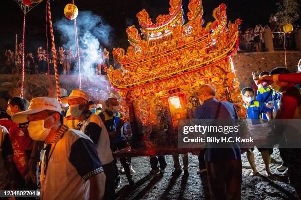 Pilgrims prepare water lanterns during the Hungry Ghost Festival on August 21, 2021 in Keelung, Taiwan. The lanterns are placed in the water and lit...